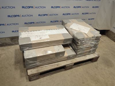 Plusieurs cartons sont empilés sur une palette devant un mur.
