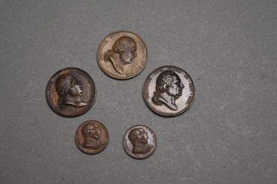 quatre types de pièces différents posés sur une table, dont l'une au milieu