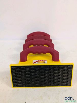 un gros plan d'une brosse de nettoyage rouge et jaune posée sur une surface blanche
