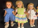 five dolls that are lined up on a black surface