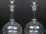 une paire de carafes en verre transparent posées sur un support noir