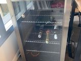 a small wine cooler sitting in the corner of a room