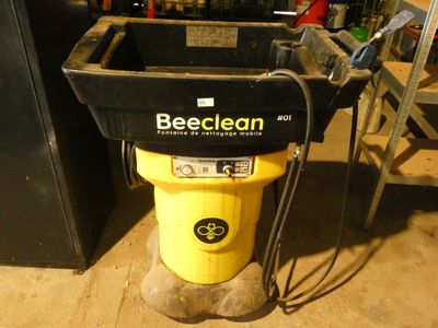 un seau jaune sur lequel est apposée une étiquette noire, dans un garage