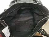 the inside of a black purse with a tag on it