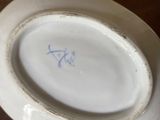 a person holding a plate with a blue writing on it