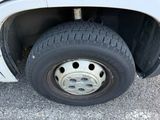 a white truck with a flat tire on the road