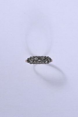 un gros plan d'une bague en diamant posée sur une surface blanche
