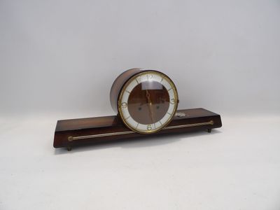 une petite horloge posée sur un socle en bois