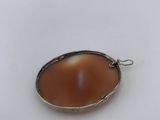 a silver pendant with a brown stone in the center
