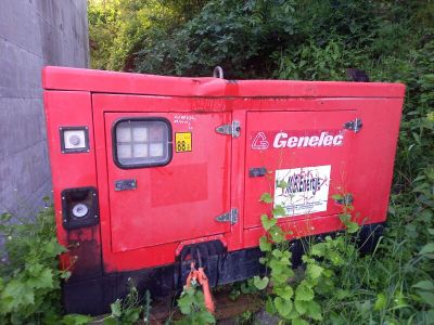 a red generator that is sitting in the grass