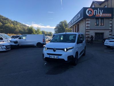 une camionnette blanche garée devant un immeuble devant lequel sont garées des voitures