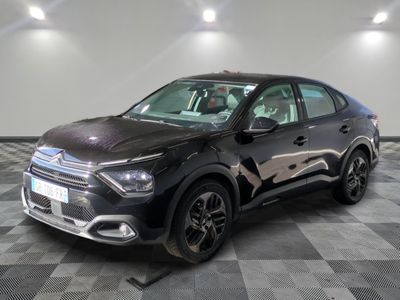 la voiture noire est garée sur un sol en damier dans le garage