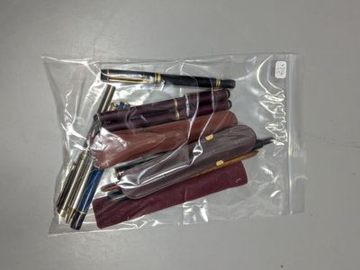 quatre stylos dans un sachet transparent posé sur une table