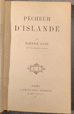 un livre ouvert posé sur une table à côté d'une tasse de café