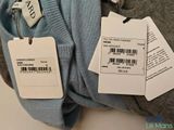 two tags attached to the back of a sweater