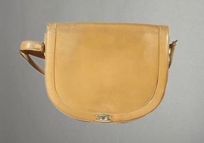 une photo d'un sac à main beige accroché à un mur