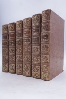 plusieurs vieux livres sont alignés sur une surface blanche