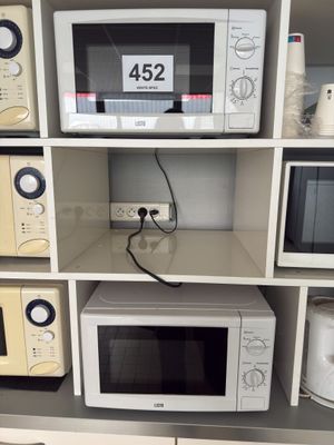 many microwaves and toasters on display in a store
