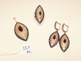 two pairs of earrings and a pair of earrings on a white surface