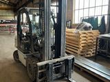 a forklift in a warehouse with pallets on the floor