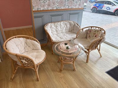 three wicker chairs and a table in the corner of a room