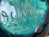 a close up of a blue vase with writing on it