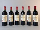 six bouteilles de vin sont alignées sur une table