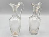 une paire de vases en verre transparent posés sur une table blanche
