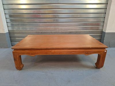 une table basse en bois avec une porte en métal en arrière-plan