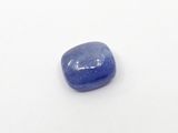a close up of a blue sapphire stone on a white surface