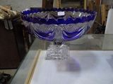 un bol en verre bleu posé sur une table en verre