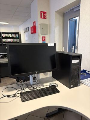 a computer desk with two monitors and a keyboard on it