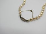 gros plan d'un collier de perles sur une surface blanche