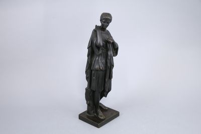 une statue noire représentant une femme tenant un livre, posée sur un socle en marbre