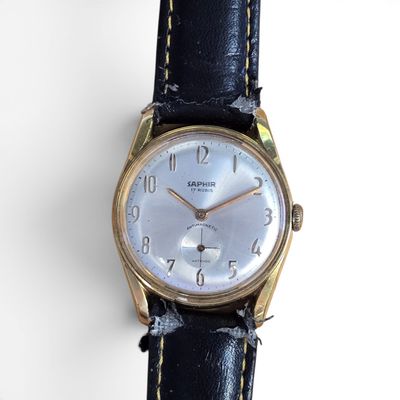 gros plan d'une montre sur une surface blanche