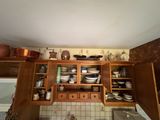 une cuisine avec beaucoup de placards et de vaisselle sur les étagères