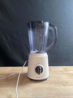 a blender sitting on a wooden table with a black background