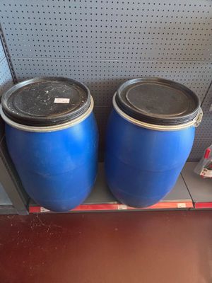 two blue barrels sitting on a shelf next to each other