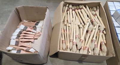 two boxes of toothbrushes sitting next to each other on the floor