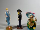 three figurines of different styles and colors are displayed against a white background