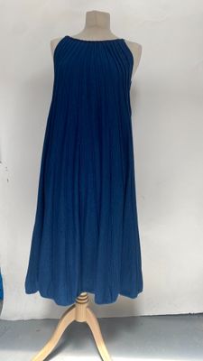 blue dress on a mannequin stand in front of a white wall