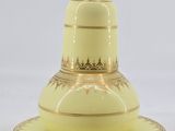 a yellow vase and saucer on a white table