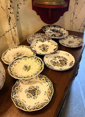 de nombreuses assiettes sur une table, avec une horloge en arrière-plan