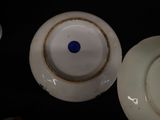 a white plate with a blue dot on it next to a white plate with a blue dot on it