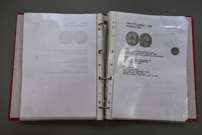 a red binder with a picture of a coin inside of it