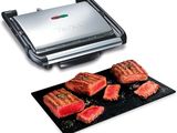 a close up of a grill with steaks and meat on it