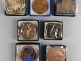 Six sortes de chocolats sont disposées dans de petites boîtes sur une table.