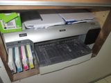 a printer sitting on top of a cabinet next to a pile of papers
