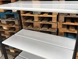 a close up of a shelf in a warehouse with pallets in the background