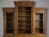 une photo d'une grande bibliothèque en bois avec deux portes et des tiroirs